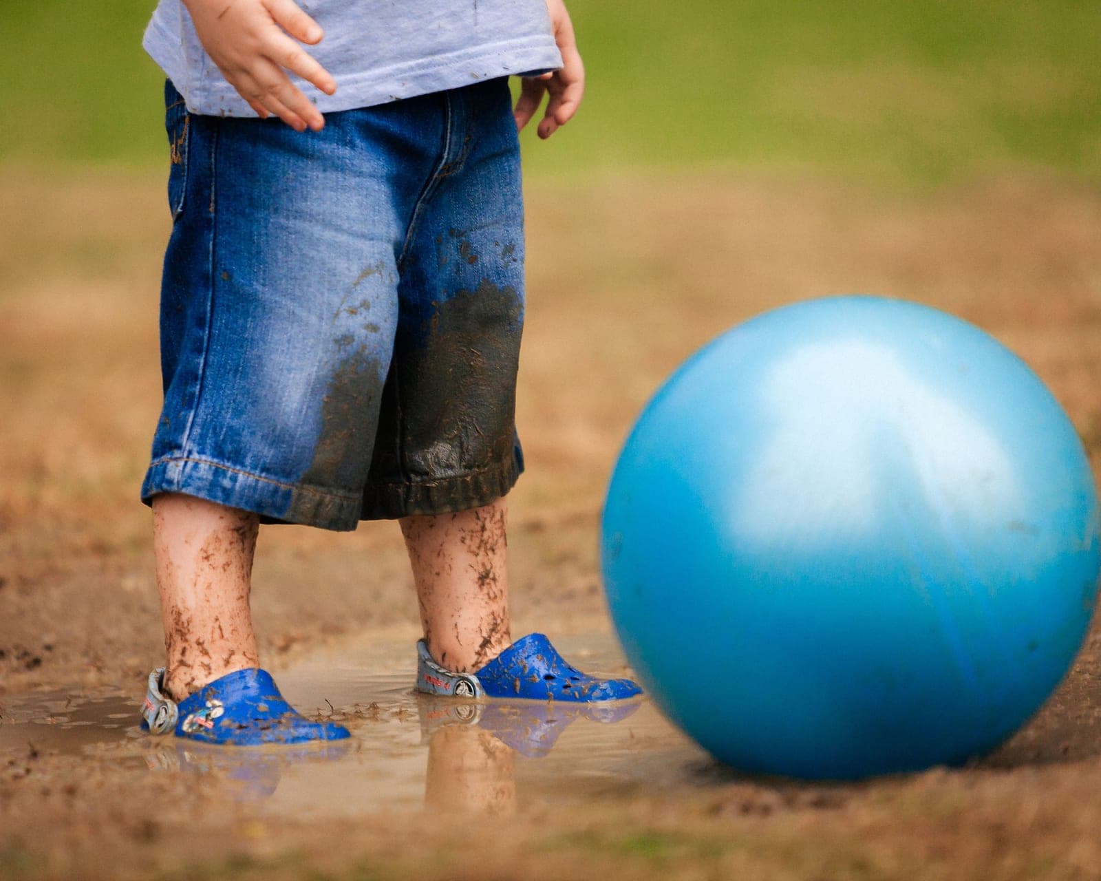 Toddler soccer shoes next to a ball