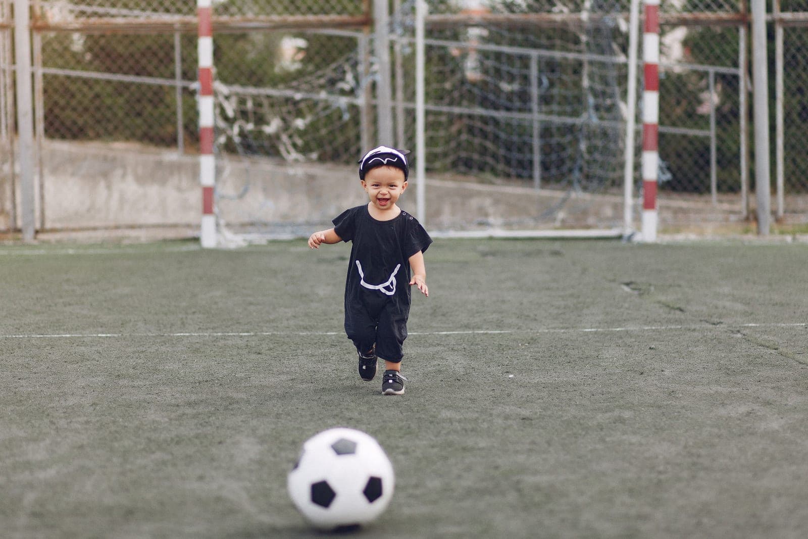 A young child playing with a soccer ball outdoors on grass