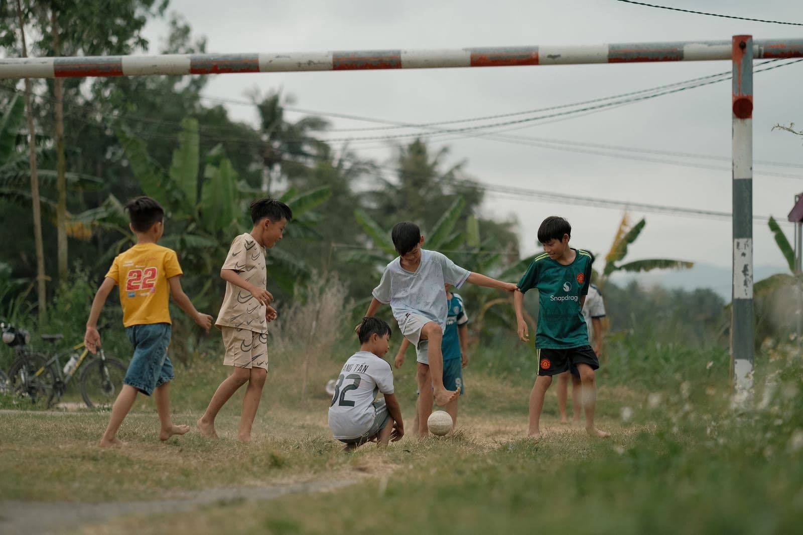 Children of different ages playing soccer on a grass field