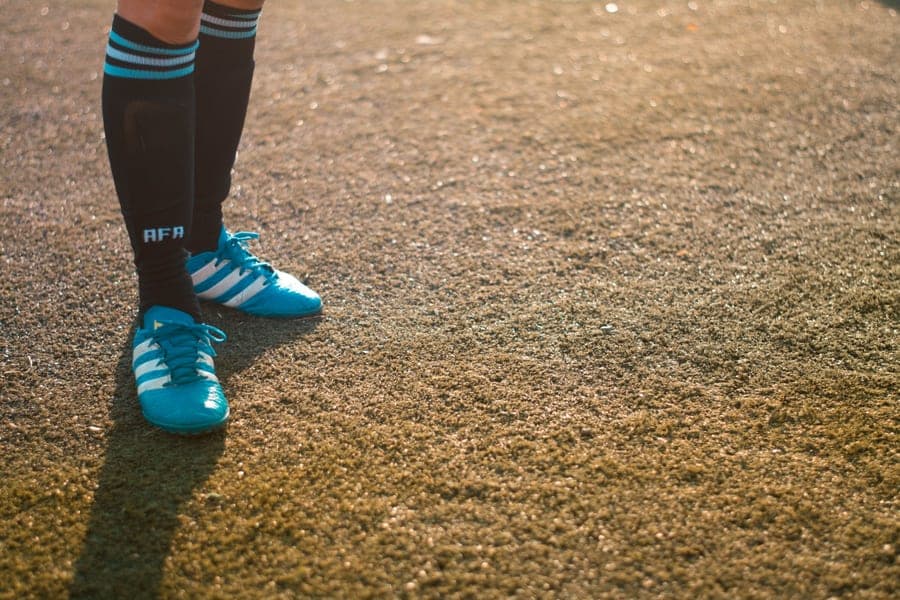 Blue youth soccer footwear photographed on a neutral background