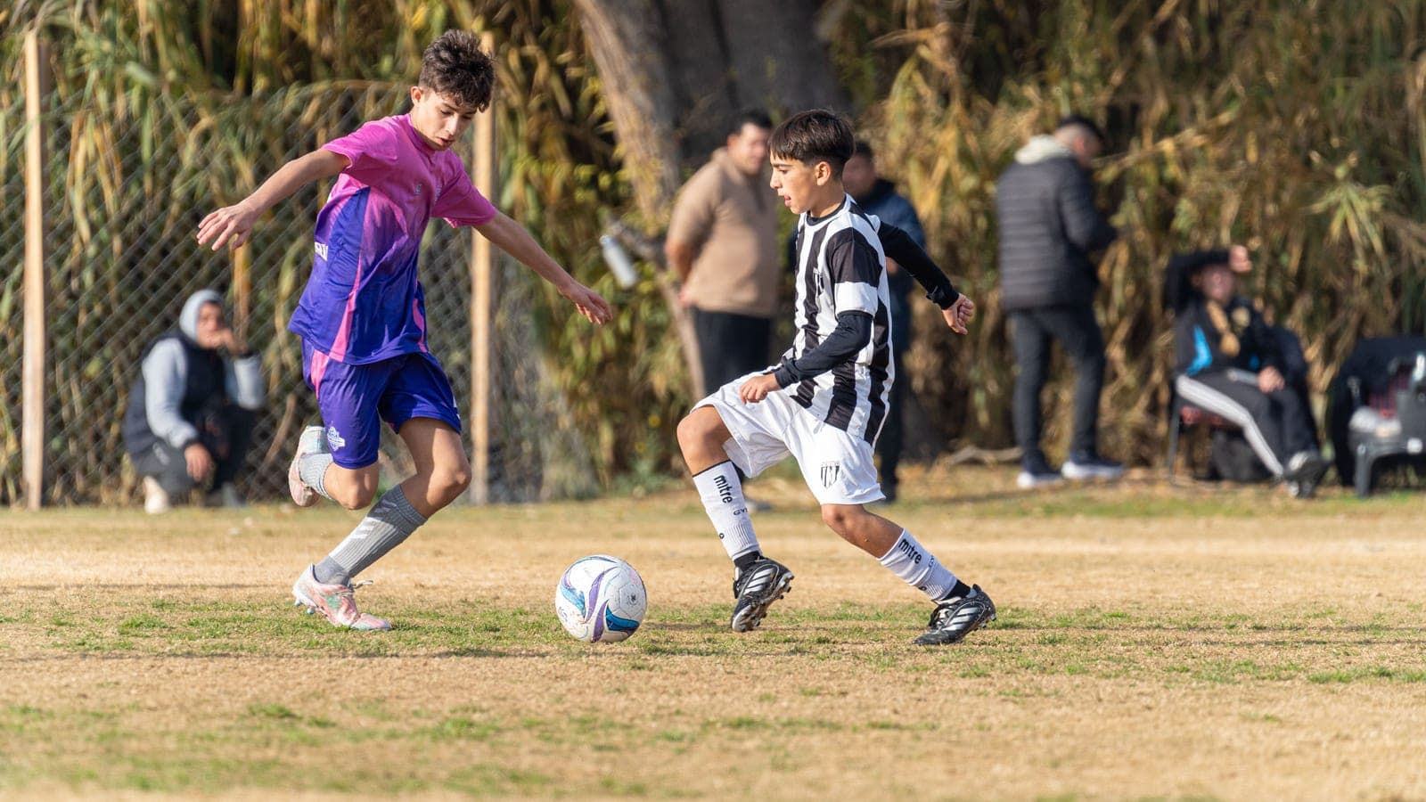 A competitive youth soccer match in progress on a grass field