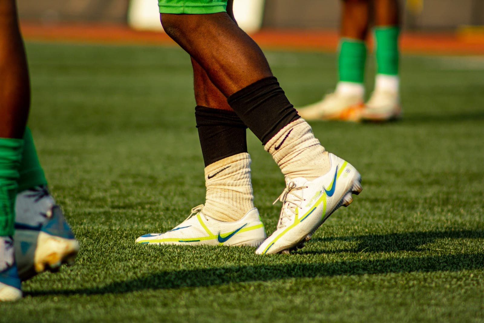 A player pulling up a soccer sock over a shin guard